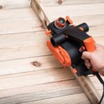 Applying fine-grit sandpaper gently to fix the unfinished kitchen woodwork with non-drying stain